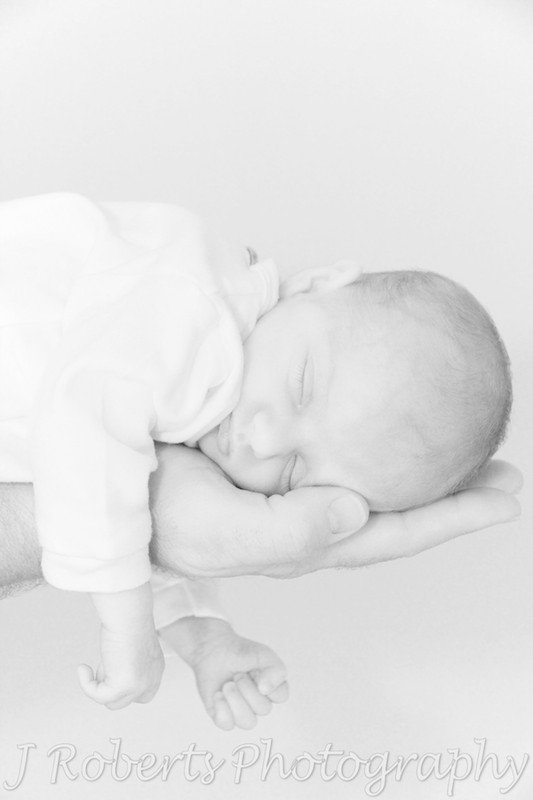 Baby sleeping in father's hand - newborn portrait photography sydney
